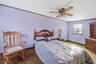 Bedroom featuring a ceiling fan, crown molding, and light colored carpet