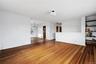 Unfurnished living room with dark wood-style floors and a chandelier