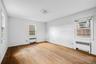 Empty room with radiator heating unit and light wood finished floors
