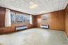 Unfurnished room with radiator heating unit and wooden walls