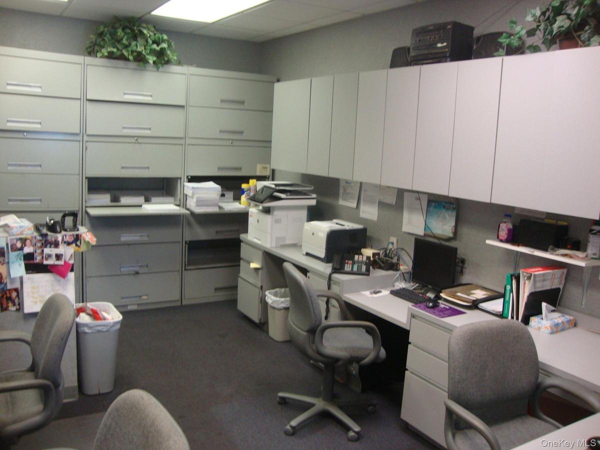 Office space featuring a drop ceiling and built in study area