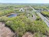 Birds eye view of property with a water view and a view of trees