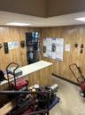 Workout room with a paneled ceiling, wood walls, and light flooring