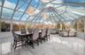 Sunroom with marble tiled floors, high vaulted ceiling, and a chandelier