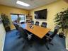 Carpeted office with a drop ceiling and baseboards
