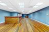 Unfurnished room featuring hardwood / wood-style flooring, a paneled ceiling, and a bar
