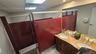 Full bathroom featuring double vanity, a shower stall, light tile patterned floors, tile walls, and a drop ceiling
