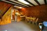 Dining room featuring wood walls, beam ceiling, stairs, and baseboard heating