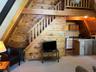 Carpeted living room featuring wooden walls and wooden ceiling