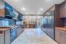 Kitchen with modern cabinets, decorative backsplash, ventilation hood, and high quality appliances