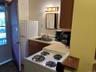 Kitchen with white appliances, light countertops, and brown cabinetry