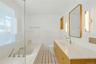 Hall bathroom with Calcutta marble flooring with teak inlay, marble tub and shower, snow white marble sink