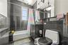 Bathroom with tile walls, shower / tub combo with curtain, tile patterned floors, radiator, and vanity