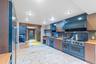 Kitchen featuring open shelves, light countertops, high quality appliances, and backsplash