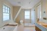 Primary bath limestone tile throughout, river view shower