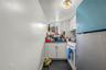 Kitchen with freestanding refrigerator, electric stove, white cabinetry, and dark countertops