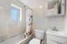 Bathroom featuring shower / bath combo with shower curtain, vanity, and tile walls
