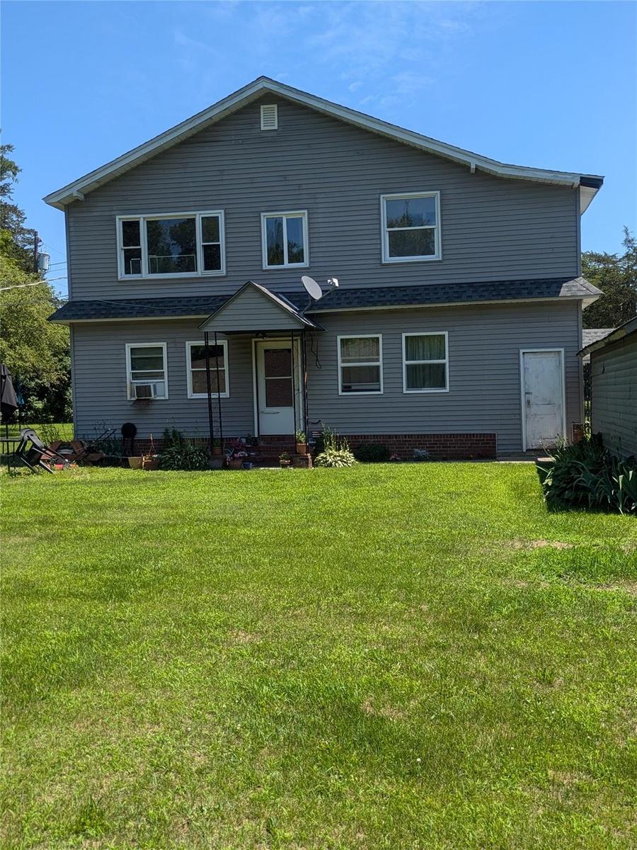 Rear view of property featuring a yard and cooling unit