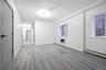 Unfurnished room featuring a baseboard heating unit, light wood finished floors, and a glass covered fireplace