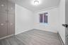 Unfurnished bedroom featuring a baseboard heating unit and light wood finished floors