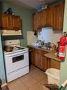 Kitchen with sink, backsplash, white range with electric cooktop, and light tile patterned floors