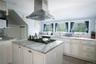 Kitchen featuring light stone countertops, sink, stainless steel gas cooktop, island exhaust hood, and light hardwood / wood-style floors