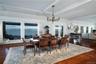 Dining area featuring beam ceiling, crown molding, a notable chandelier, a water view, and dark hardwood / wood-style flooring