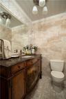 Bathroom with tile walls, vanity, ornamental molding, and toilet