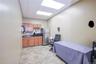 Kitchen featuring a paneled ceiling, freestanding refrigerator, dark countertops, an office area, and brown cabinets