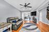 Living area with light wood finished floors, stairway, recessed lighting, and ceiling fan