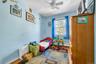 Bedroom with wood finished floors, a ceiling fan, and a baseboard heating unit