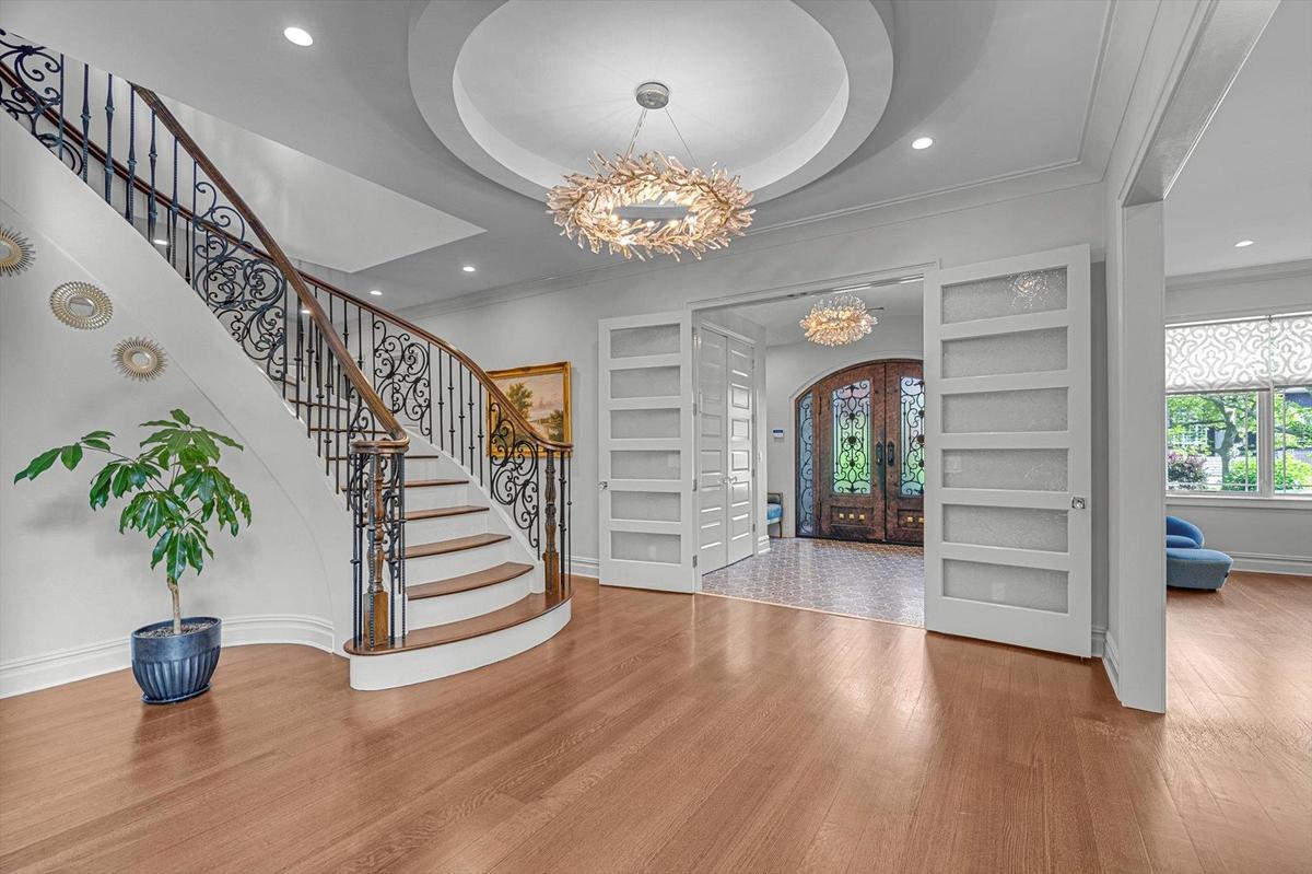 Foyer featuring a chandelier, wood finished floors, stairway, crown molding, and recessed lighting