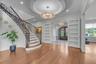 Foyer featuring a chandelier, wood finished floors, stairway, crown molding, and recessed lighting