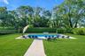 View of swimming pool featuring a patio area, view of wooded area, and a fenced backyard