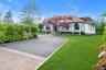 View of front of home with Circular driveway and a front lawn