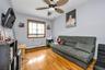 Living room with light wood-type flooring, a baseboard heating unit, and ceiling fan