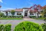 Mediterranean / spanish-style home featuring french doors, a chimney, and a front lawn