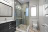 Full bath with vanity, a stall shower, and tile walls