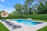 View of swimming pool featuring a lawn, a patio area, and a pool with connected hot tub
