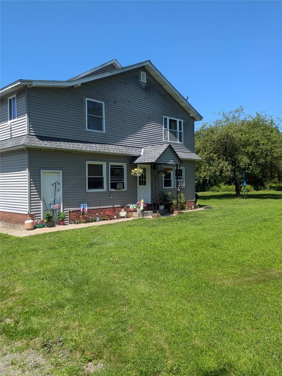 View of front facade with a front yard and roof with shingles