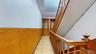 Corridor featuring light floors and wainscoting