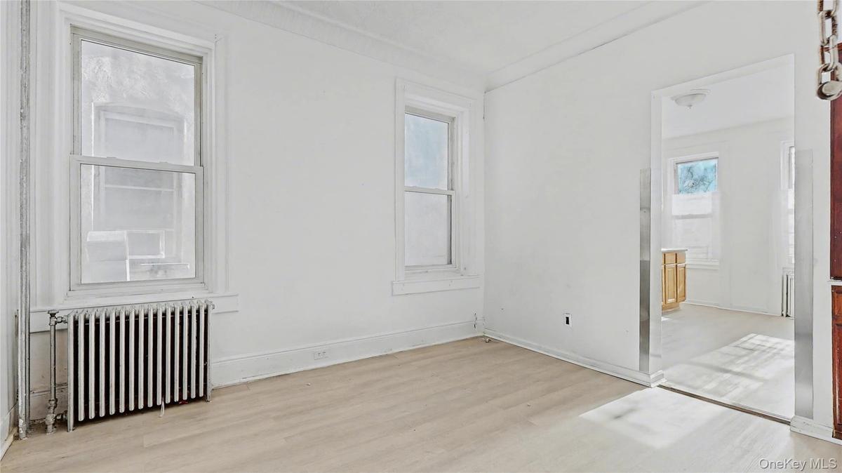 Empty room with radiator and light wood-style flooring