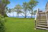 View of grassy yard with stairway and a water view