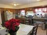Kitchen featuring gas range, radiator heating unit, a textured ceiling, brown cabinetry, and freestanding refrigerator