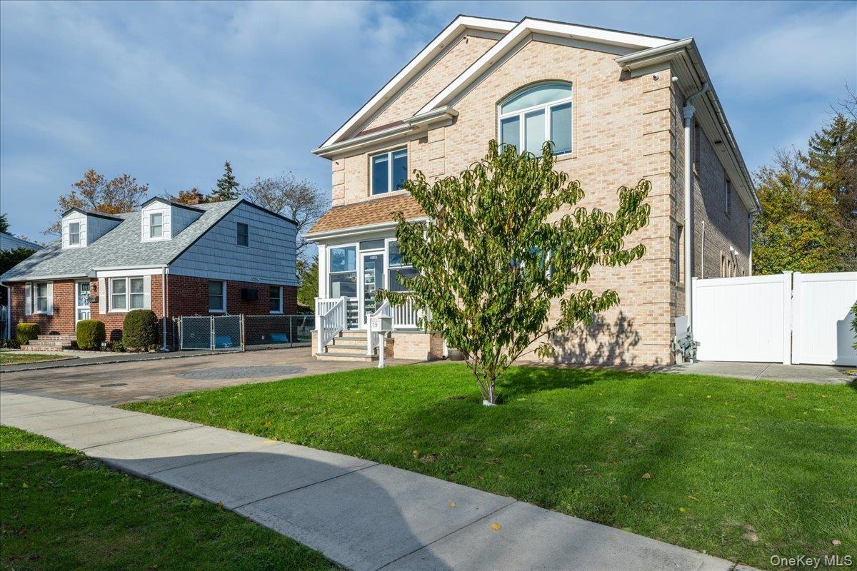 View of front of property with a gate and brick siding