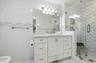 Bathroom with vanity, a shower stall, light marble finish floors, tile walls, and a bidet