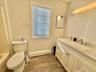 Full bath featuring a baseboard heating unit, vanity, and wood finish floors