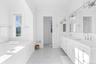 Bathroom with double vanity, a garden tub, and ornamental molding