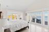 Bedroom with french doors, access to exterior, vaulted ceiling, and a water view