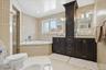 Full bathroom featuring light tile patterned floors, vanity, a bath, tile walls, and a stall shower